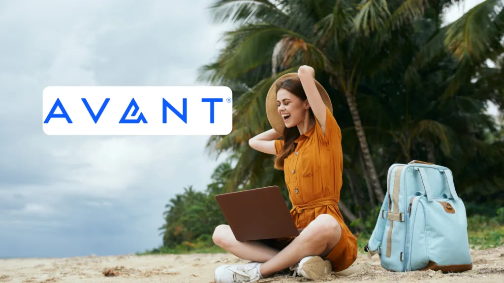 A woman sitting on the beach with her laptop happy