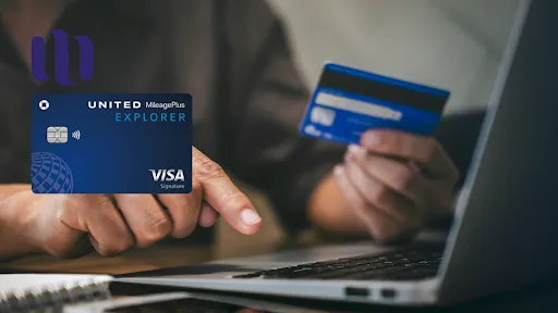 man uses notebook holding United Explorer credit card