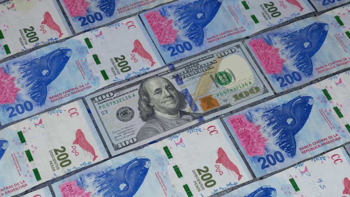 Billetes de pesos argentinos y dólares estadounidenses, simbolizando la comparación entre el dólar blue y la moneda local en Argentina.